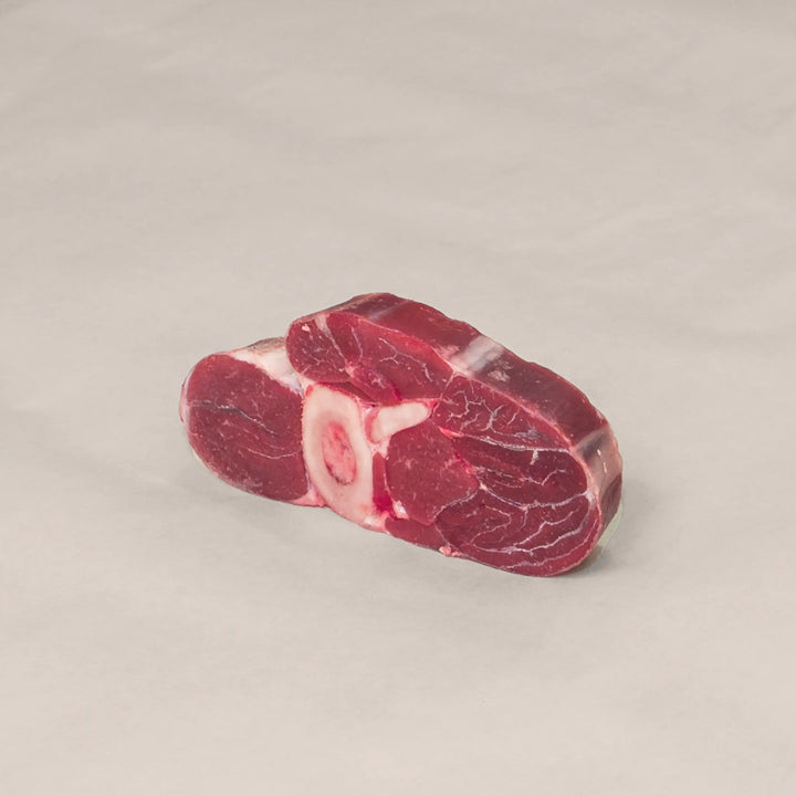 Signature Veal Osso Buco cut, showcasing rich marbling and bone for slow cooking.