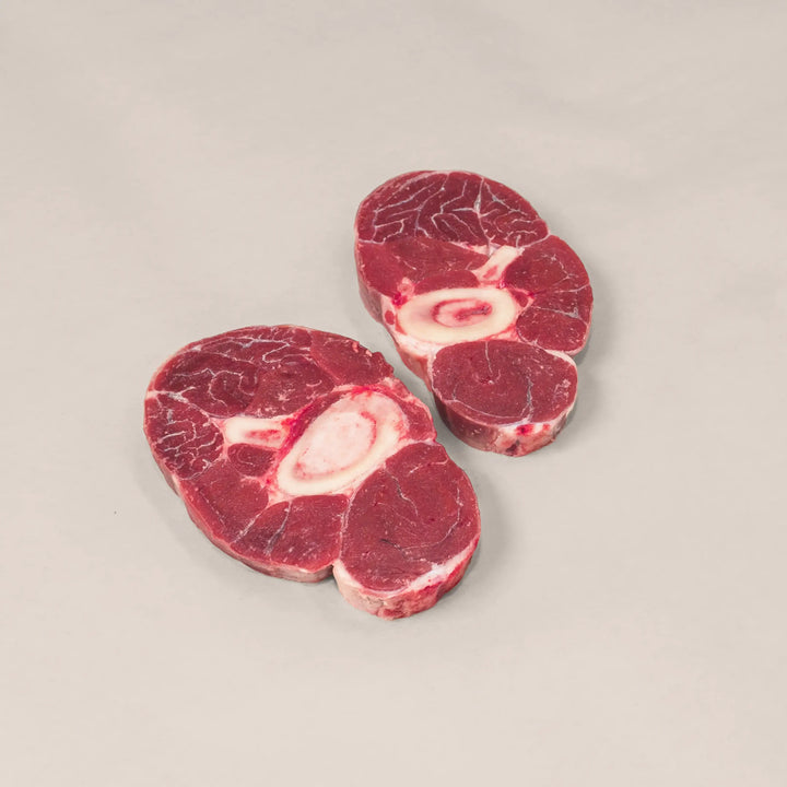 Hand-cut veal shanks for osso buco, showcasing rich marbling and bone for maximum flavor and tenderness.