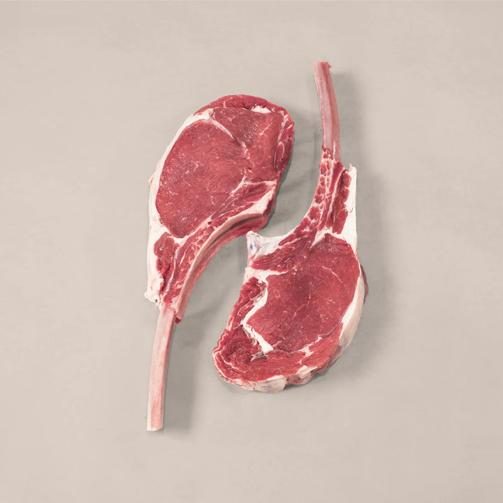 Two gourmet veal chops showcasing marbling and tenderness, perfect for a luxurious dinner experience.