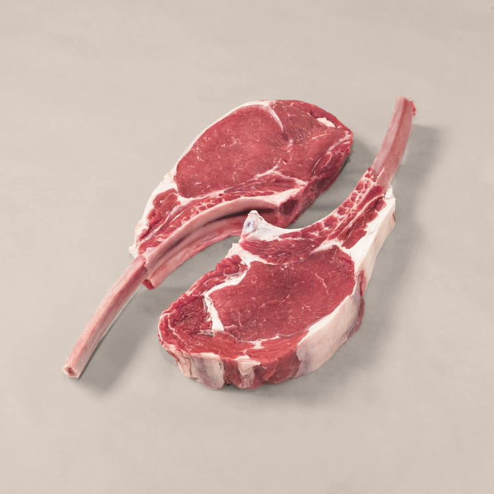Two gourmet veal chops showcasing marbling and tenderness, perfect for luxury dinners.