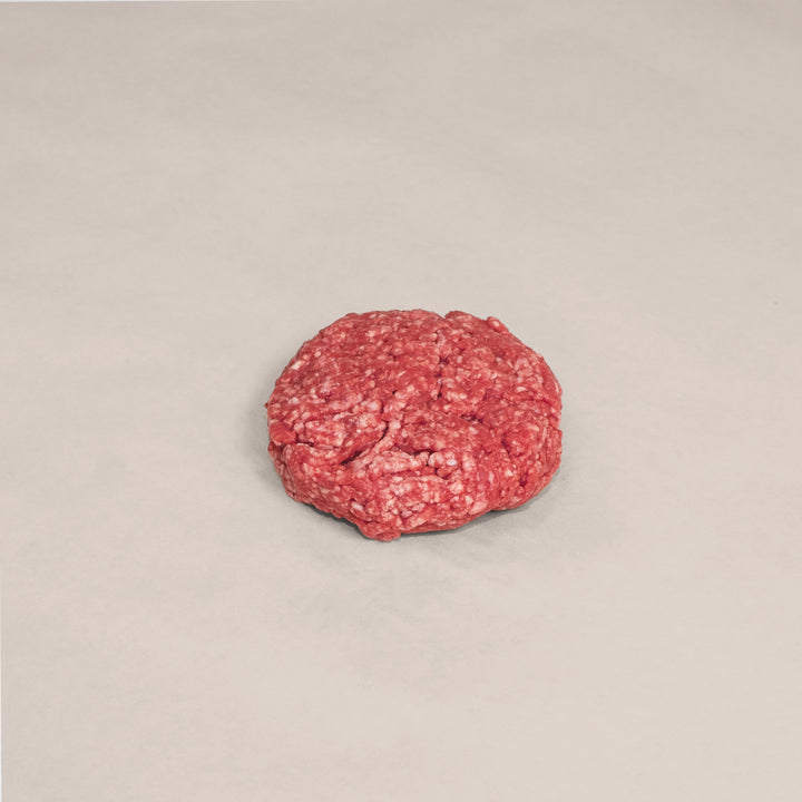 Raw hand-formed beef patty made from premium Canadian beef for a flavorful burger experience.