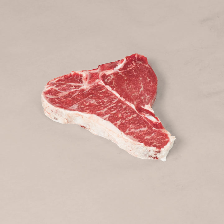 Premium Porterhouse T-Bone Steak showcasing marbling and T-shaped bone, perfect for a delicious meal.