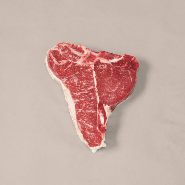 Premium Porterhouse T-Bone Steak showcasing marbling and T-shaped bone, perfect for a delicious meal.