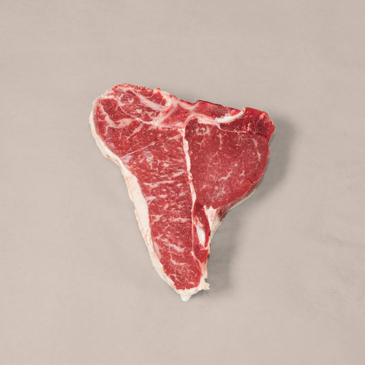 Premium Porterhouse T-Bone Steak showcasing marbling and T-shaped bone, perfect for a delicious meal.